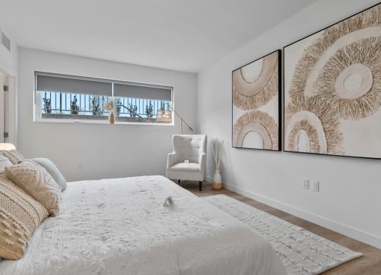 a bedroom with a large bed and two large pictures on the wall