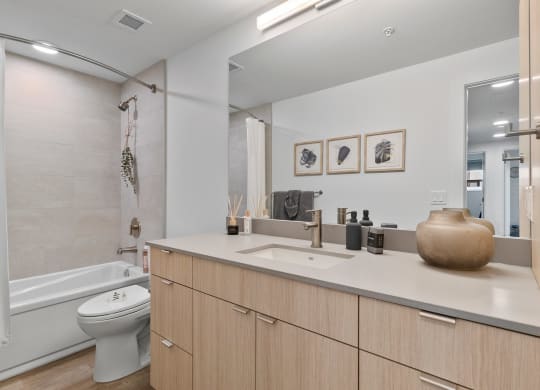 a bathroom with a toilet sink and bathtub in a 555 waverly unit