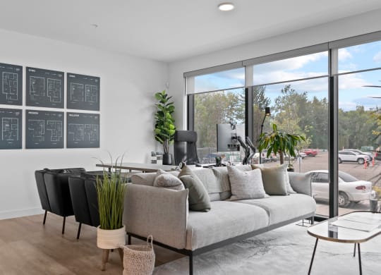 a living room with a couch and chairs in front of a large window