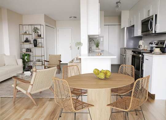 a living room and kitchen with a table and chairs