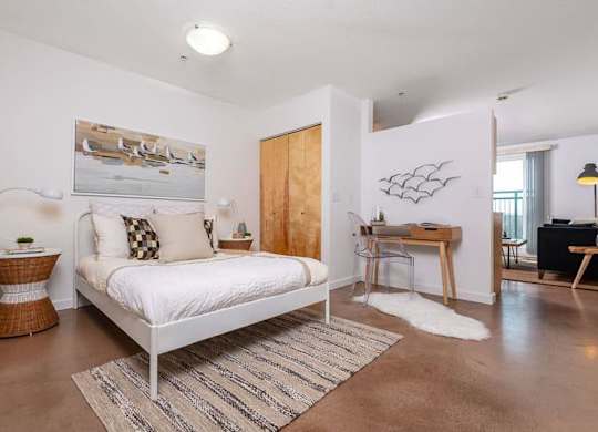 a bedroom with a white bed and a desk