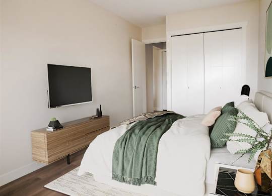 a bedroom with a bed and a television on the wall