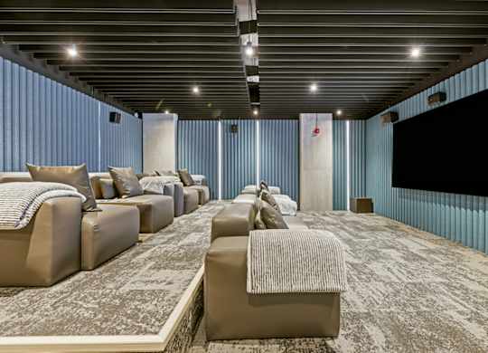 A room with a carpeted floor and a large screen on the wall.
