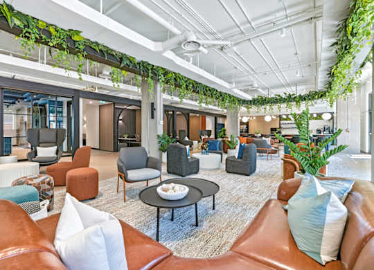 A modern living room with a variety of seating options and plants.