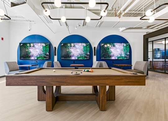 A pool table with a blue screen behind it.