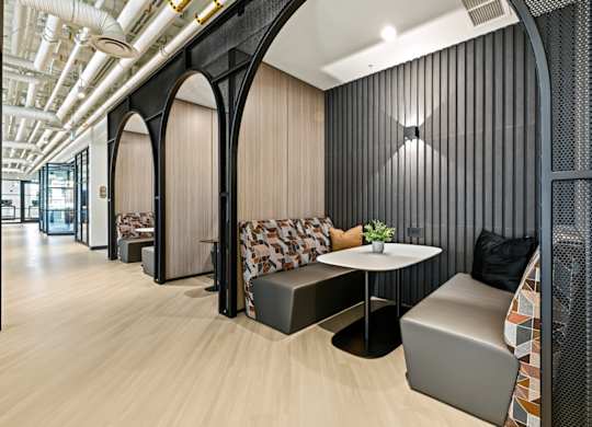 A modern office space with wooden floors and black accents.