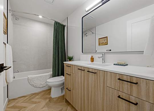 A bathroom with a toilet, sink, and a mirror.