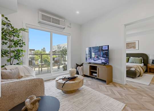 A living room with a flat screen TV and a large window.