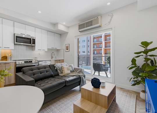 A modern living room with a grey sofa and a white coffee table.