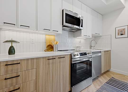 A modern kitchen with wooden cabinets and stainless steel appliances.