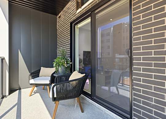 A patio with a chair and a table with a potted plant on it.