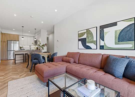 A living room with a pink couch and a glass coffee table.
