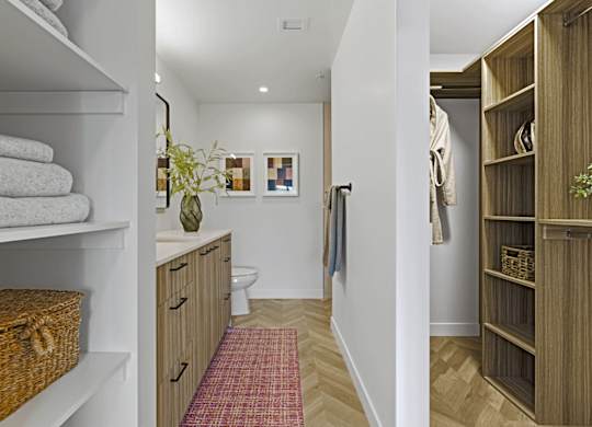 A bathroom with a towel on a shelf and a basket on the floor.