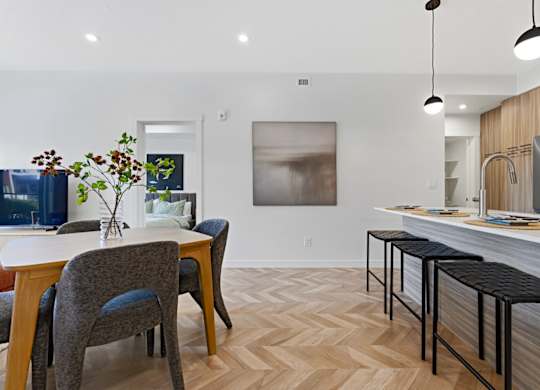 A kitchen with a dining table and chairs.