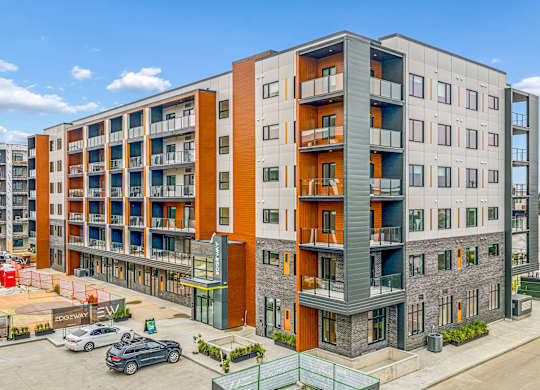 A modern apartment building with orange and grey accents.