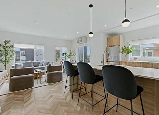 A modern kitchen with a dining area and a living room.