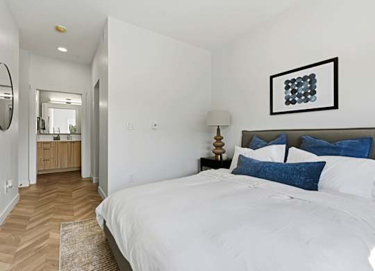 A bedroom with a large bed and a mirror on the wall.