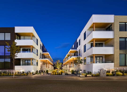 A modern apartment building with balconies and large windows.