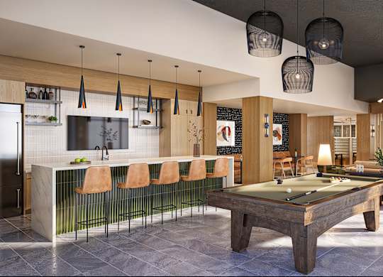 A billiard table is in the middle of a room with a bar and a television.