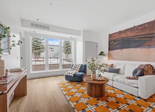 A living room with a white couch, a coffee table, and a large painting on the wall.