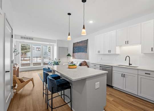 A kitchen with a white countertop and blue chairs.