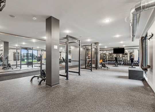 A gym with a variety of equipment including treadmills, weights, and exercise machines.