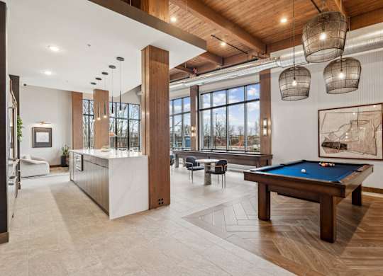 A room with a pool table and a large window.