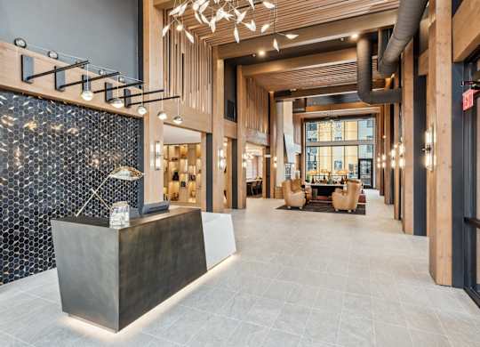 A modern lobby with a reception desk and a large window.