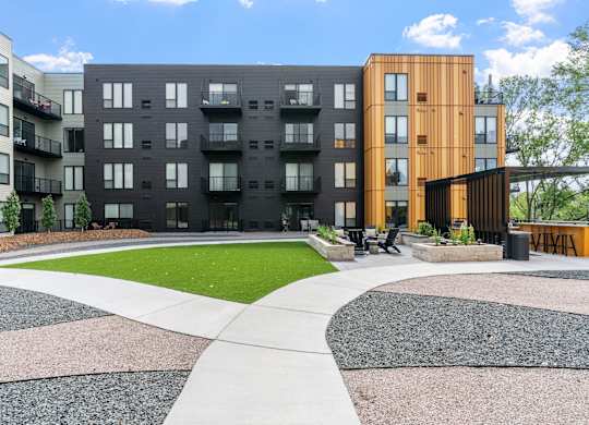 A modern apartment complex with a mix of black and wooden buildings.