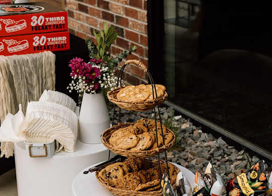 A basket of snacks sits on a table next to a sign that says