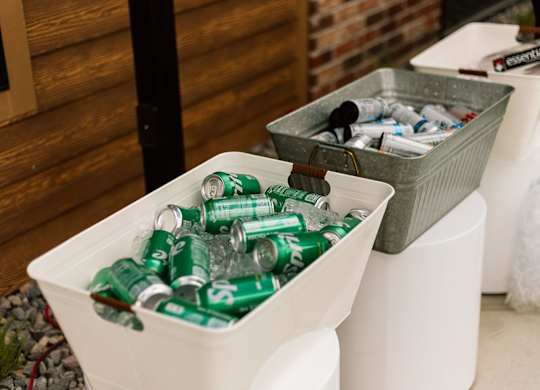 A white container is filled with green cans.