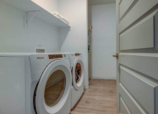 A Whirlpool washing machine is in a small laundry room.