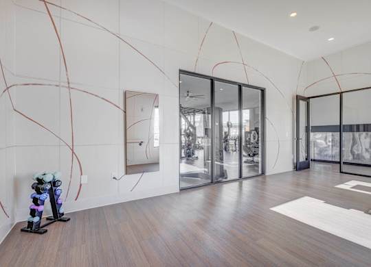 A modern room with a treadmill and a mirror on the wall.