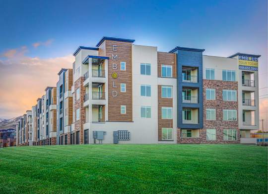 A row of modern apartment buildings with the name "EMBLON" on the side.