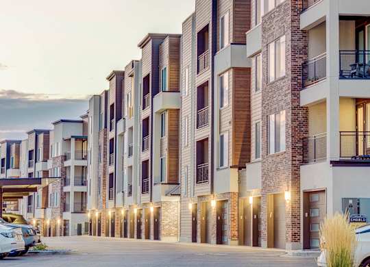A row of modern apartment buildings with garages and balconies.
