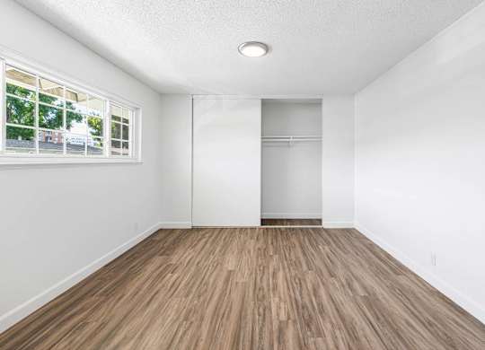 A room with wooden flooring and a window.