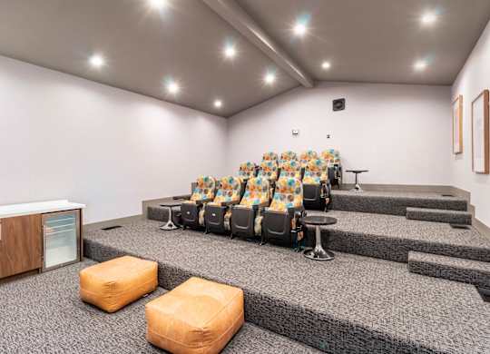 A room with a row of chairs and a speaker on the stage at Chaparral Apartments, Palmdale, CA