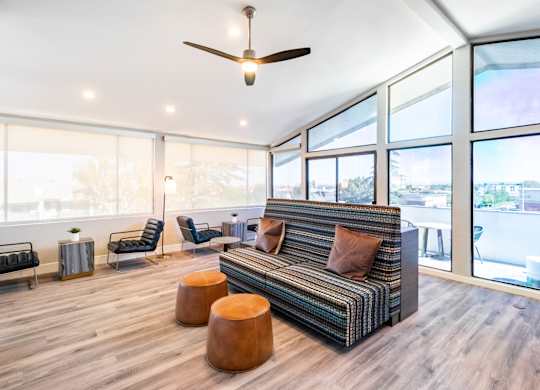A living room with a striped couch and a ceiling fan at Chaparral Apartments, Palmdale 93551