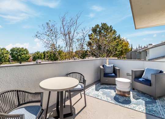 A patio with a table, chairs, and a couch at Chaparral Apartments, Palmdale