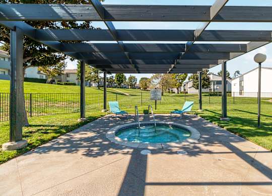 A hot tub is under a canopy in a backyard at Chaparral Apartments, Palmdale