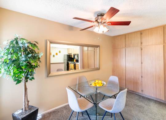 A dining room with a glass table and chairs. at Chaparral Apartments, Palmdale 93551