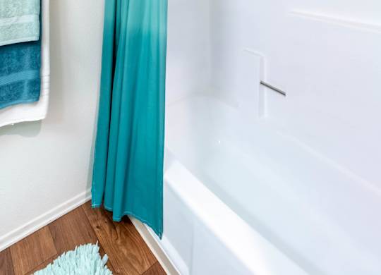 A white bathroom with a blue shower curtain.
