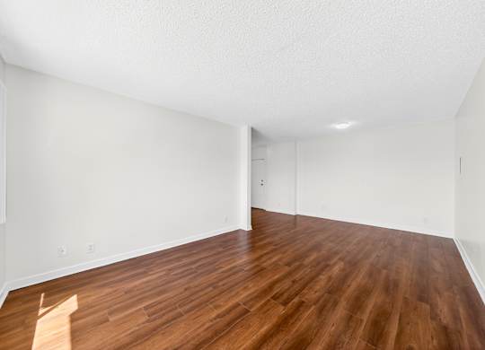 A room with wooden flooring and white walls.