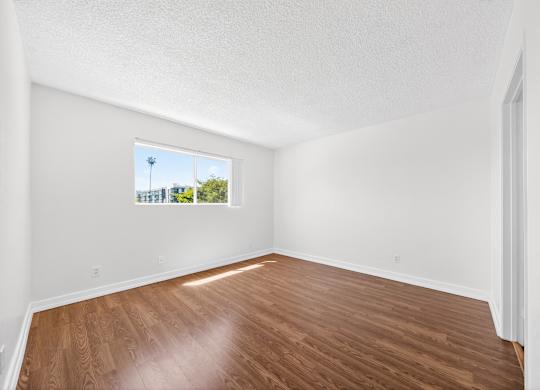 Empty room with wooden floor and white walls.