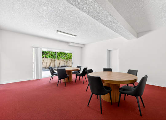 A conference room with a round table and chairs.