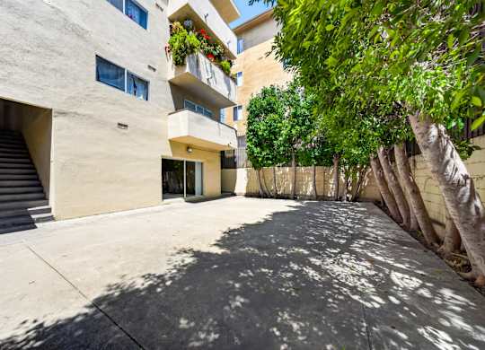 A concrete building with a tree in front.