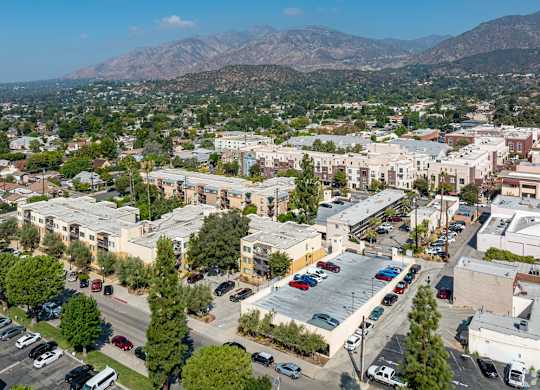 A parking lot with cars and a mountain in the background at Oak Park Apartments, Monrovia, 91016