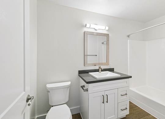 A white toilet sits next to a sink in a small bathroom.