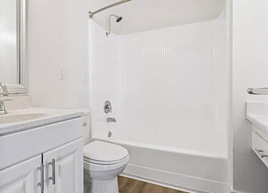 A white bathroom with a toilet, sink, and bathtub.