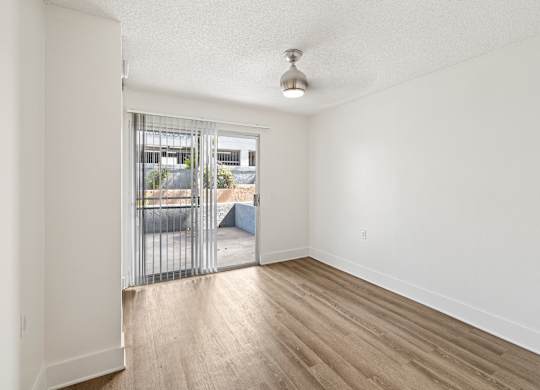 A room with a white wall and a wooden floor.